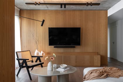 Mesa ratona revestida en microcemento (Achalilas) y silla Jeanneret iluminada con una lámpara amurada de Imdi.