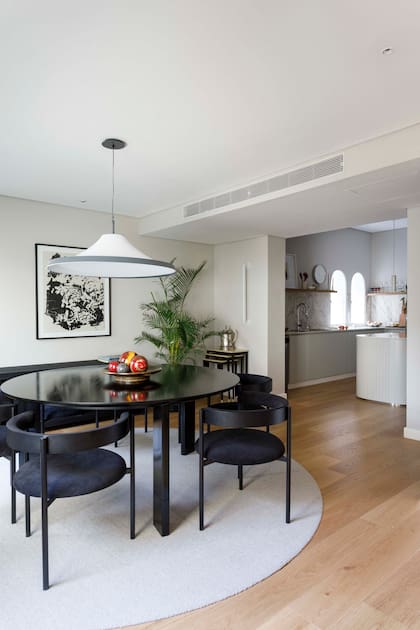 Mesa redonda (Marini). Sillas (Ries). Alfombra (Kalpakian Casa). Luz colgante (Aldacour). Apliques lineales de pared (Huup Iluminación)