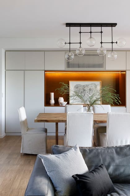 Mesa, sillas y lámpara colgante (Landmark). Xilografía (Hueyar). Piezas de cerámica artesanal en bizcocho (Antes Pella). Revestimiento de piso ‘Legni Tropical’ (Ilva).