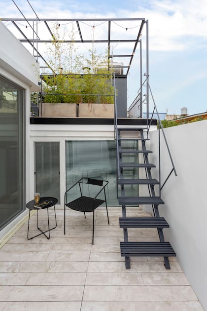 Mesa y silla (Increa). El piso (Premoldeck) es atérmico, antideslizante y no necesita mantenimiento. Arriba está la parrilla, con un frente del mismo tono gris que el usado en el interior