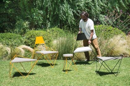 Mesa y sillas de hierro y cemento, en una combinación moderna y de líneas finas para integrar al jardín.