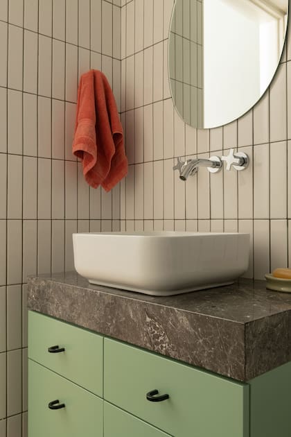Mesada de mármol Tundra Black y un vanitory laqueado en verde (Atelier Brux) con tiradores de IKEA. A los cerámicos blancos les hicieron colocar pastina verde musgo para resaltar su geometría.