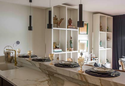 Mesada de Purastone Prima 'Macchia Vecchia' (De Stefano). Anafe vitrocerámico (Teka). Luminarias (IDEA).