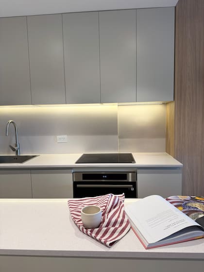 Mesada de Silestone, amoblamiento y alacenas hechos a medida en melamina 'Gris ceniza' (Faplac). Pileta (Ponthus) con grifería 'Vigo' con pico extensible (Peirano), horno y anafe eléctricos (Samsung)