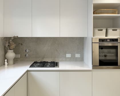 Mesada, Silestone Blanco Norte (Canteras del Mundo por Marmolería Cervaiole). Muebles de cocina (diseñados y ejecutados por el estudio, el bajo mesada en el tono Agreeable Gray de Sherwin Williams) y revestimiento en alzada (Portobello Moonlight Sand Natural, SBG). Bandeja (Sol Palou Deco), florero (Orilla Home), escultura Venus de Milo (Roma Doma).