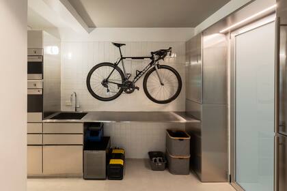 Mesada y espacio de guardado de acero inoxidable (Fallone Studio por Inox Atelier). Amuraron en la pared un soporte para la bicicleta.