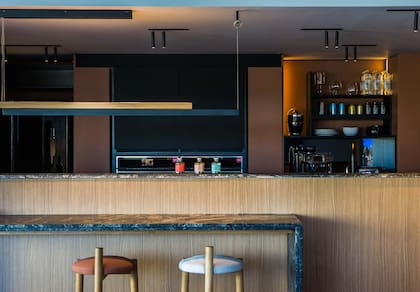 Mesada y plano vertical en granito nacional 'Amadeus' leather (De Stefano) trabajado por Giannetta Mármoles. Los muebles fueron ejecutados por el estudio Pio Auguri. Hornos de Tekka.