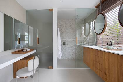 Mesadas de cuarzo blanco y vanitory, cajoneras y detalles de madera de Freijó natural.