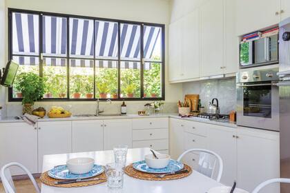 Mesadas de mármol de Carrara. Muebles de madera laqueada (diseño y realización Estudio Celaá). Grifería (Ikea). Horno embutido, extractor y anafe (Franke).