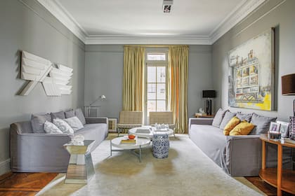 Mesas bajas y auxiliares de diseño propio. Lámpara negra (Fábrica de Luz), sillones ‘Barcelona’ comprados en remate y lámpara Tolomeo. Sobre la pared izquierda, un relieve blanco, obra de Williams.