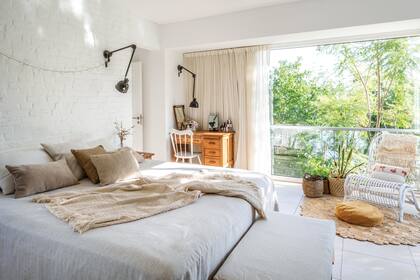 Mesas de luz (Mercado de Pulgas), Almohadones y manta con flecos (Huitrú). Lámparas de pared (Electro Tucumán). Sillón blanco (Landmark). Alfombra de yute (Nadzieja).