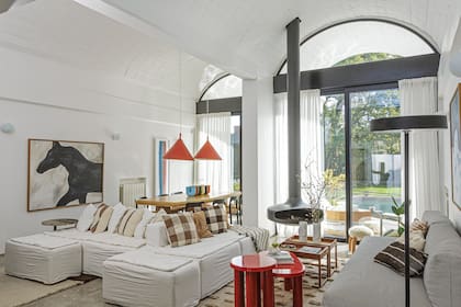 Mesas laqueadas en rojo (Estudio MMS). Mesas de madera rectangulares (La Base). Lámpara de pie (DIMM). Sillón tejido blanco y negro (Oda Estudio).