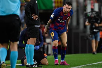 Messi, atendido fuera del campo, preocupado por su muslo izquierdo.