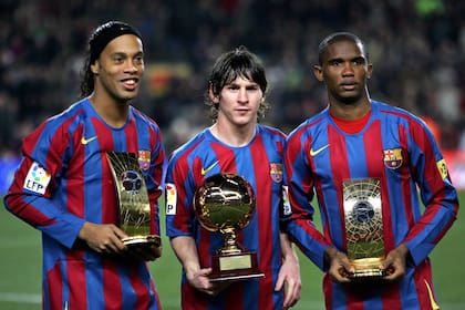 Messi con Ronaldinho y Eto´o muestran sus trofeos en el Camp Nou antes del partido frente a Celta, el 20 de diciembre de 2005