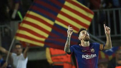 Messi festeja; de fondo, los hinchas de Barcelona con las banderas de Cataluña