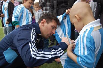 Messi firmando una camiseta para uno de sus invitados en el predio