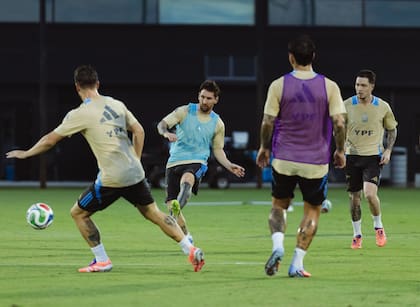 Messi hace un pase en un entrenamiento; a su izquierda lo respalda Aníbal Moreno