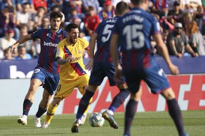 Messi maniobra entre varios jugadores de Levante
