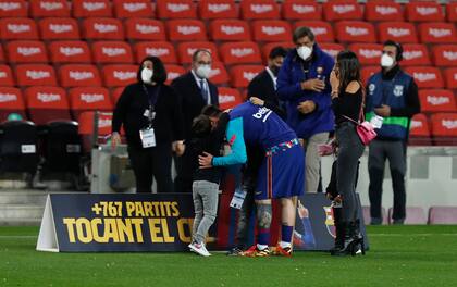 Messi se saluda con uno de sus hijos tras la foto familiar que se tomó por el reconocimiento de Barcelona a su récord de presencias