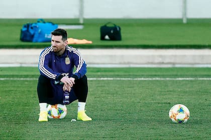 Messi, sentado sobre la pelota en un pasaje de la práctica en Valdebebas (Madrid).