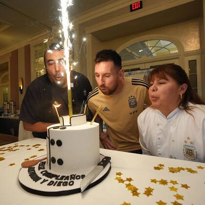 Messi soplando la vela por su cumpleaños con Diego y Antonia, cocineros de la selección.
