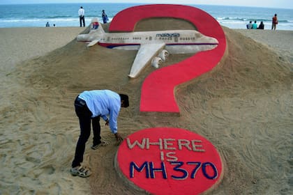 El artista de arena indio Sudarsan Pattnaik crea una escultura de arena del avión desaparecido de Malaysia Airlines, MH370, en la playa de Puri en el estado oriental de Odisha el 7 de marzo de 2015. 