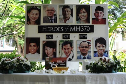 Un cartel que muestra a la tripulación de cabina del desaparecido vuelo MH370 de Malaysia Airlines se muestra durante una oración en una escuela en Petaling Jaya el 8 de marzo de 2016. 