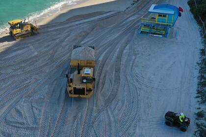 Los camiones mueven toneladas de arena 