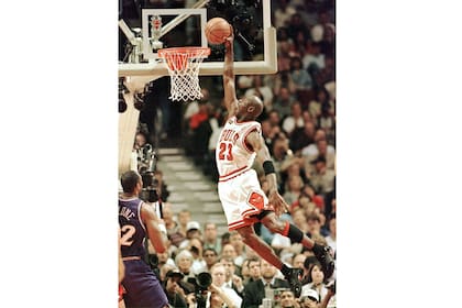 Michael Jordan vuela para hacer una volcada mientras Karl Malone de los Utah Jazz lo observa. un clásico de la NBA de todos los tiempos