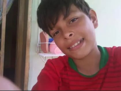 Michell posando ante la cámara del celular cuando era niño