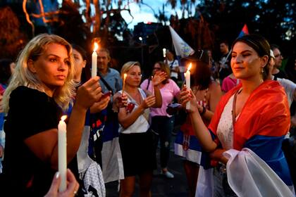 Miembros de la comunidad serbia local realizan una vigilia frente al hotel en el que fue hospedado Novak Djokovic