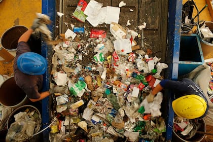 Miembros de la cooperativa de cartoneros Alelí separan los residuos reciclables en el sector del Centro Verde Automatizado que utiliza la tecnología de mayor avanzada del país