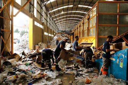 Miembros de la cooperativa de cartoneros Alelí separan los cartones en el sector del Centro Verde Automatizado que utiliza la tecnología de mayor avanzada del país