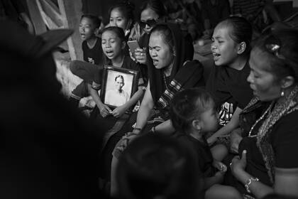 Miembros de la familia cantan durante el ritual funerario o la ceremonia de Rambu Solo en honor de Naomi Malino en la aldea de Lempo.