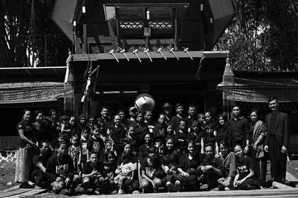 Miembros de la familia de Naomi Malino posan frente al Lakian que contiene el ataúd con su cuerpo, durante el ritual funerario o la ceremonia de Rambu Solo en su honor en la aldea de Lempo.