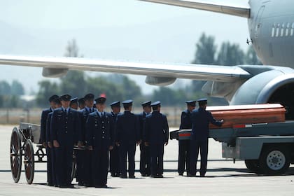 Miembros de la Fuerza Aérea de Chile descargan el ataúd con el cuerpo del ex presidente chileno Sebastián Piñera en el aeropuerto de Pudahuel en Santiago el 7 de febrero de 2024.