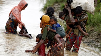Refugiados Rohingya lavan su ropa mientras cruzan un canal en Teknaf, Bangladesh