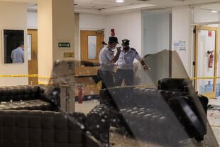 Miembros de la policía nacional de Chipre inspeccionan la sede de la emisora ​​local Sigma TV en la capital, Nicosia, el 18 de julio de 2021 después de que manifestantes contra las medidas del coronavirus atacaron las instalaciones a última hora de la noche
