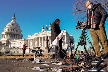 Miembros de la prensa buscan el equipamiento que haya sobrevivido el descontrol de ayer