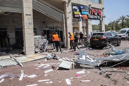 Miembros de las fuerzas de seguridad israelíes inspeccionan un edificio después de haber sido blanco de un misil disparado desde la Franja de Gaza hacia la ciudad de Ashkelon