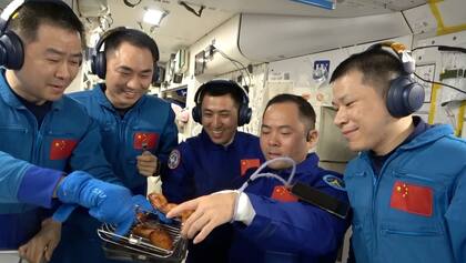 Miembros de las tripulaciones Shenzhou 20 y 21 dispuestos a comer las primeras presas de pollo cocinadas en órbita terrestre