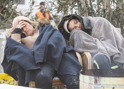 Miembros de una familia duermen junto a un fuego en Antakya, Turquía