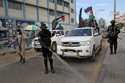 Miembros del ala armada de la Jihad Islámica palestina, las Brigadas Al-Quds, rocían desinfectante en las calles de Rafah meses atrás durante las medidas de aislamiento por la pandemia.