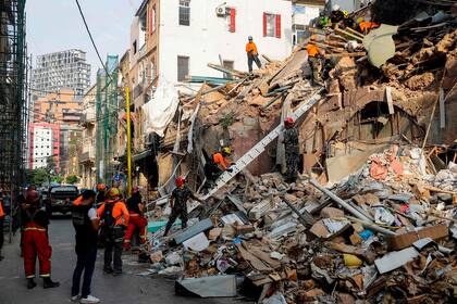 Miembros del equipo chileno trabajando en un edificio derrumbado
