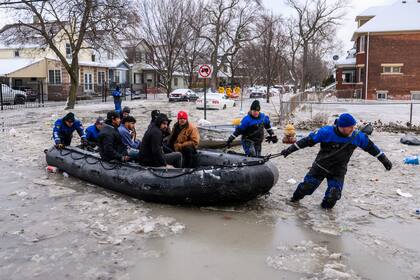 Miembros del Equipo de Buceo del Sureste de Michigan ponen a salvo a varias personas luego de que la ruptura de una tubería principal de agua provocó inundaciones masivas, el lunes 17 de febrero de 2025, en Detroit. (Andy Morrison/Detroit News vía AP)