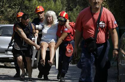 Miembros del equipo de rescate trasladan a una mujer herida