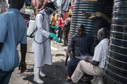 Miembros del Ministerio de Salud de Kenya desinfectan las calles del Mercado de Gikomba en Nairobi