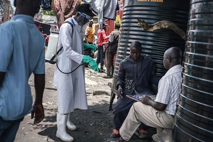 Miembros del Ministerio de Salud de Kenya desinfectan las calles del Mercado de Gikomba en Nairobi