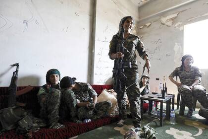 Miembros jóvenes de las SDF se refugian en una casa abandonada. "La edad no tiene nada que ver", dice una comandante adolescente. "Es una cuestión de voluntad."