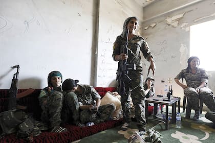 Miembros jóvenes de las SDF se refugian en una casa abandonada. "La edad no tiene nada que ver", dice una comandante adolescente. "Es una cuestión de voluntad."